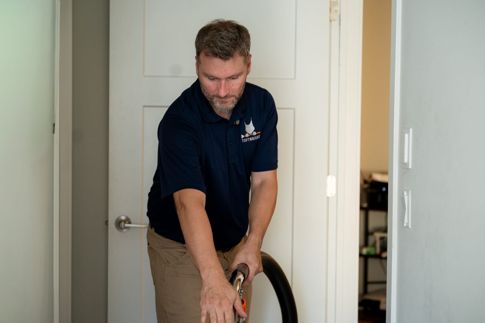 Kevin guiding an extraction wand during an in-room cleaning demonstration
