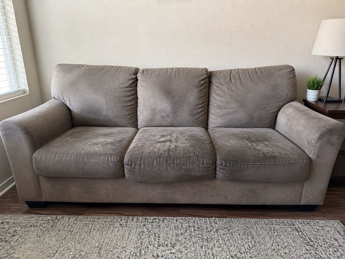 Before: A three-cushion sofa with grimy arms and seats, then the same sofa after cleaning